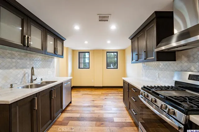 a kitchen with stainless steel appliances a sink stove and cabinets