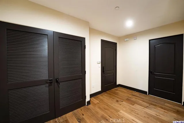 a view of empty room with wooden floor