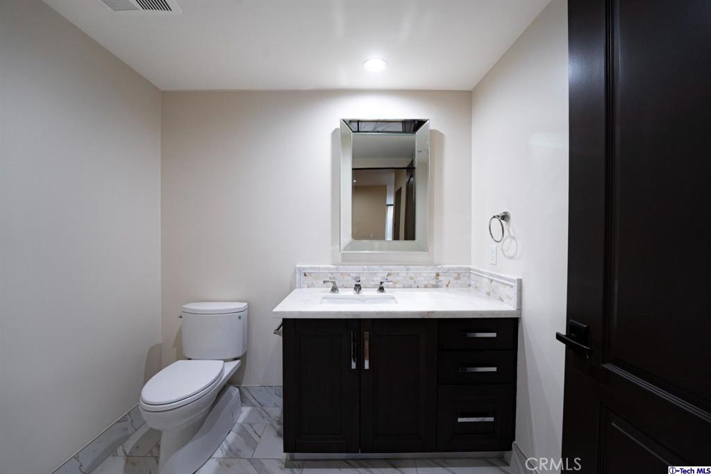 10523 Ashton Avenue, Unit 202 Los Angeles, CA 90024 - Photo 15 of 36 a bathroom with a toilet sink and mirror