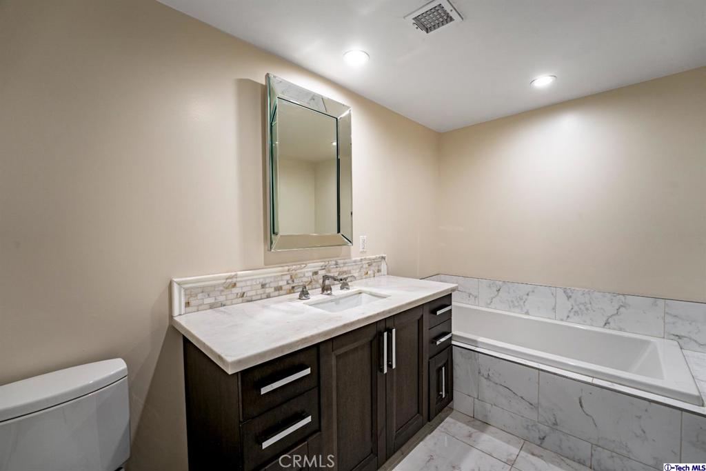 10523 Ashton Avenue, Unit 202 Los Angeles, CA 90024 - Photo 18 of 36 a bathroom with a sink a toilet and a large mirror