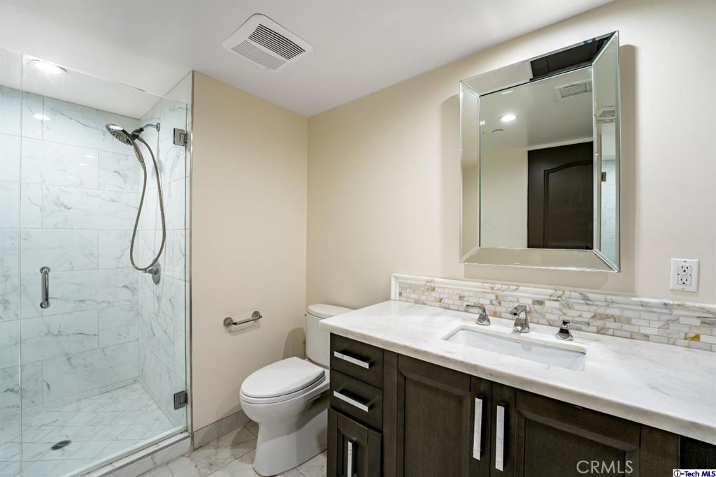 10523 Ashton Avenue, Unit 202 Los Angeles, CA 90024 - Photo 20 of 36 a bathroom with a granite countertop sink toilet and shower