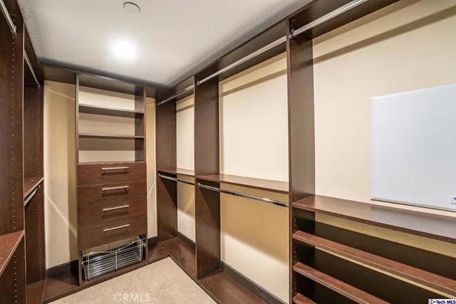 a view of walk in closet with empty racks