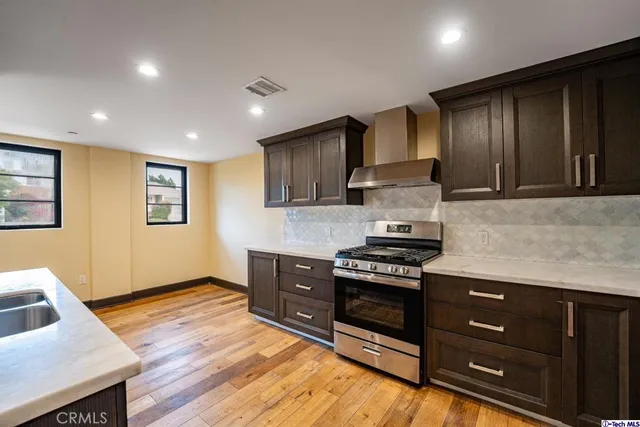 a kitchen with stainless steel appliances granite countertop wooden cabinets a stove top oven a sink and dishwasher