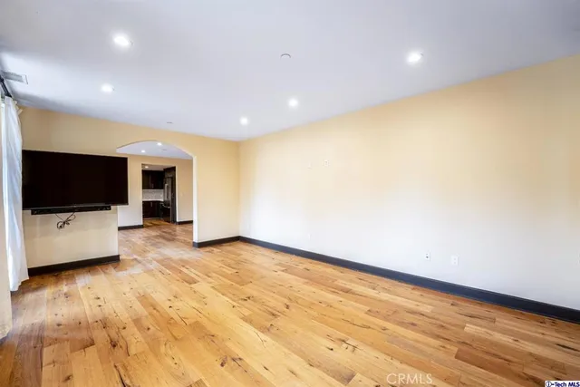 a view of room with wooden floor and flat screen tv