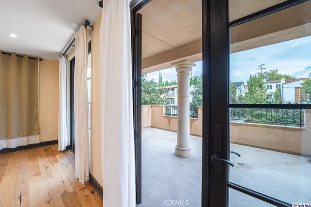 a view of a hallway with wooden floor and windows