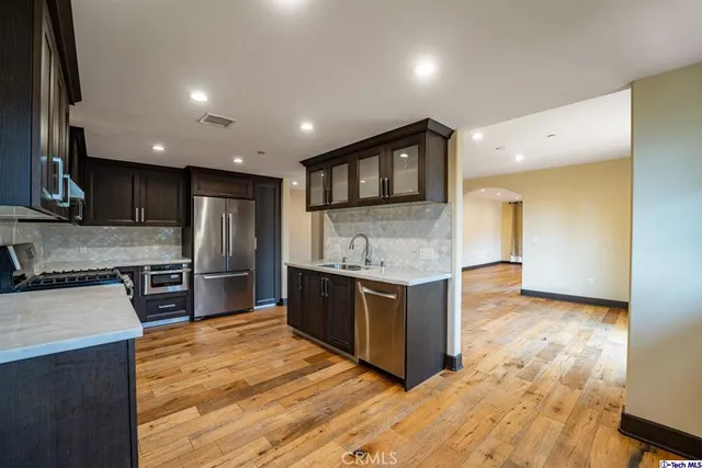 a kitchen with stainless steel appliances granite countertop a stove a sink and a refrigerator