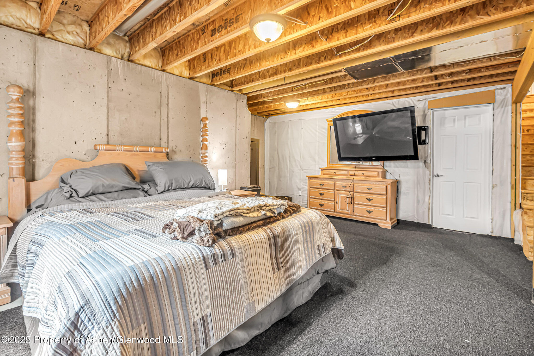 1357 West Spruce Court Rifle, CO 81650 - Photo 26 of 38 a spacious bedroom with a bed and a flat screen tv