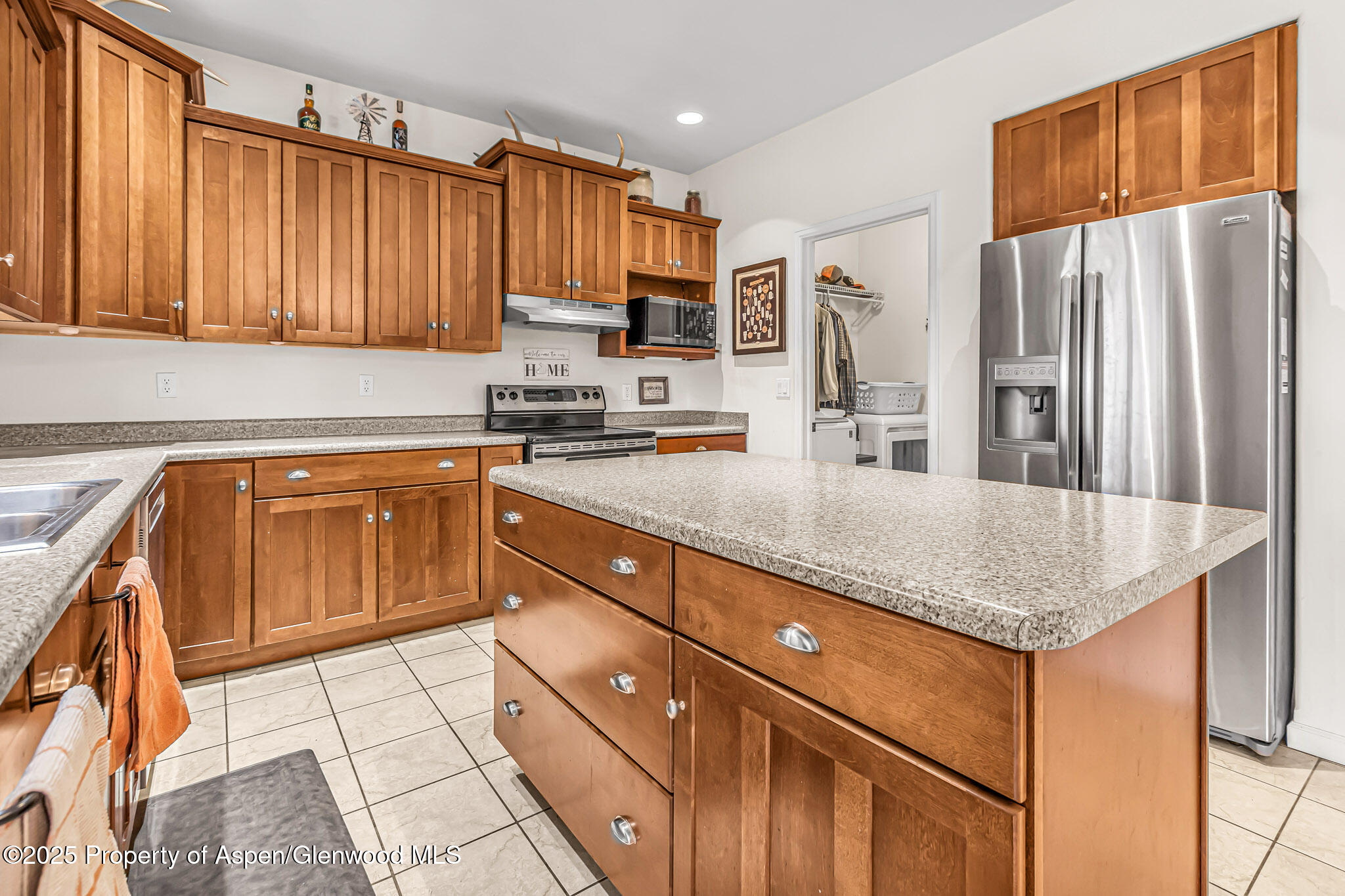 1357 West Spruce Court Rifle, CO 81650 - Photo 9 of 38 a kitchen with stainless steel appliances granite countertop a refrigerator a sink dishwasher and wooden cabinets with a granite countertops