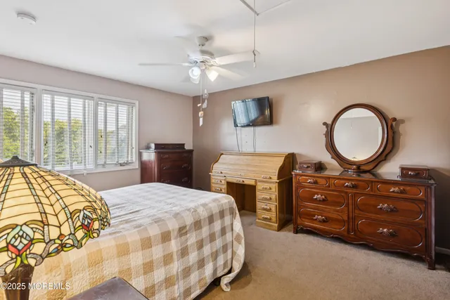a bedroom with a bed a dresser and a chandelier