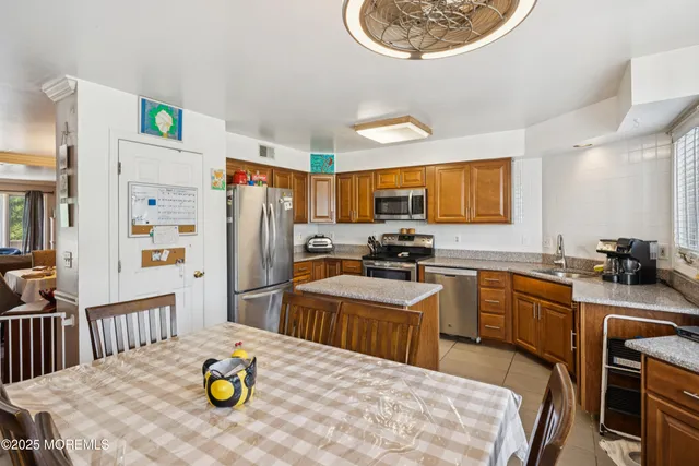 a kitchen with refrigerator and wooden floor
