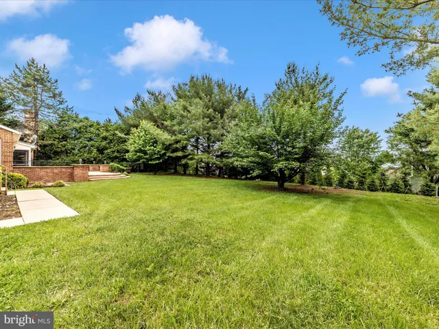 a yard with lots of green space and trees in the background