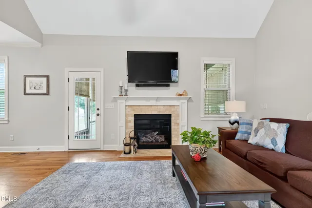 a living room with furniture a flat screen tv and a fireplace