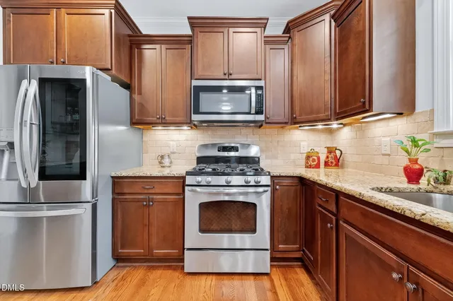 a kitchen with granite countertop a sink stove and refrigerator