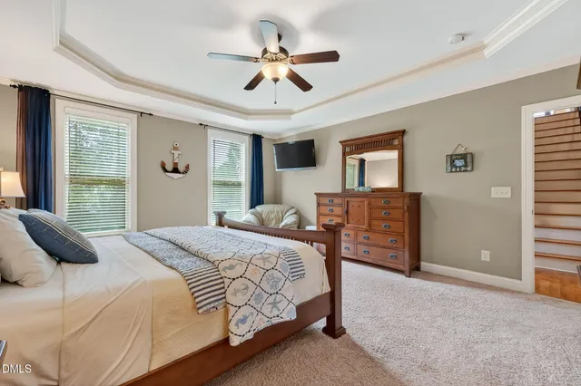 a bedroom with a bed a dresser and a chandelier