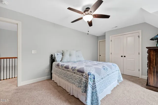 a spacious bedroom with a bed and a ceiling fan