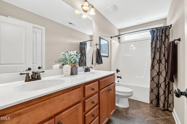 a bathroom with a double vanity sink toilet and shower