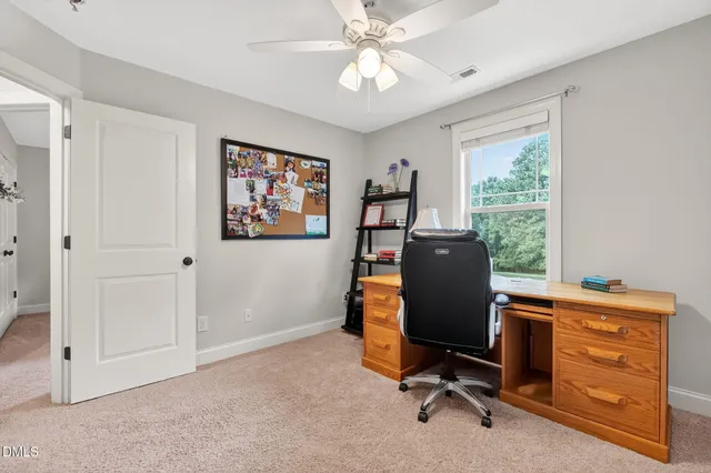 a view of a workspace with furniture and a window