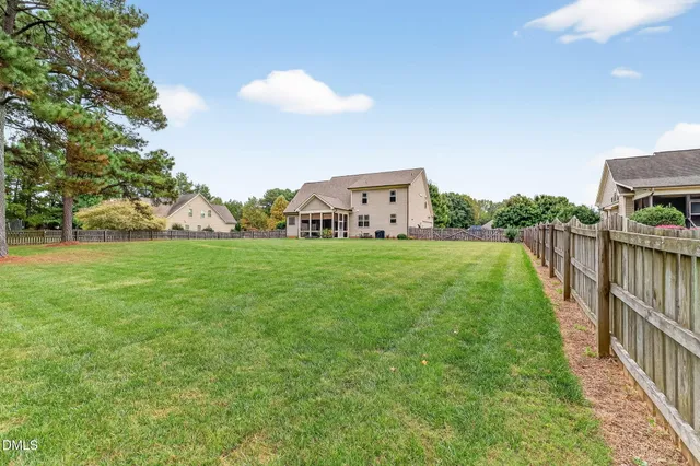 a view of a house with a big yard and large trees