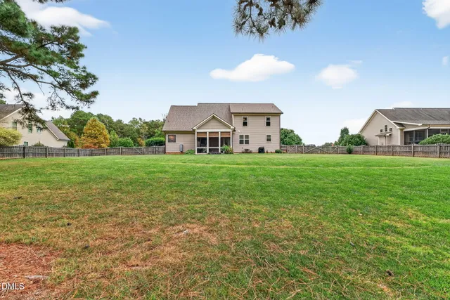 a view of a big house with a big yard and large trees