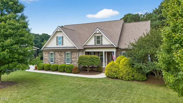 a front view of a house with a yard and potted plants
