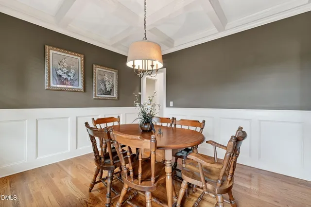a dining room with furniture a chandelier and wooden floor