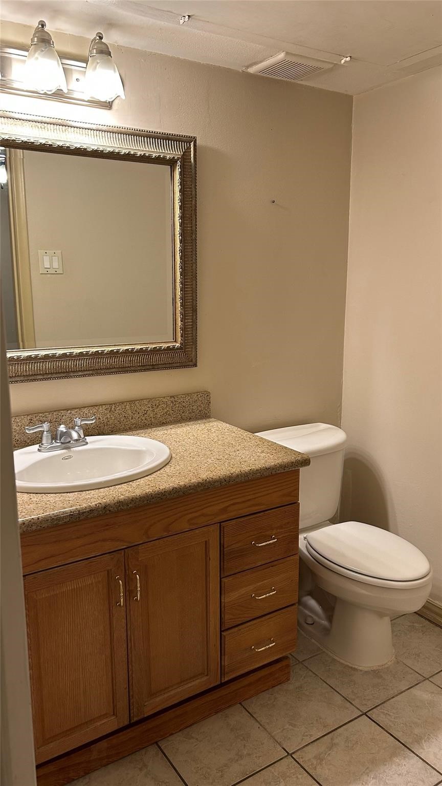 7600 Burgoyne Road, Unit 115 Houston, TX 77063 - Photo 8 of 14 a bathroom with a granite countertop toilet sink and mirror