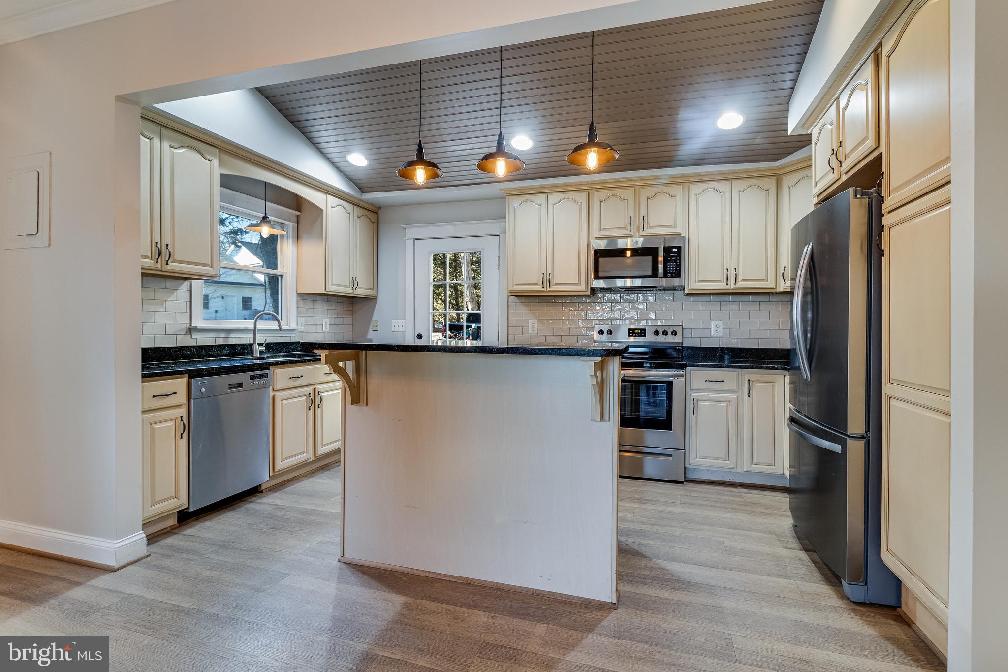28055 Old Village Road Mechanicsville, MD 20659 - Photo 11 of 56 a kitchen with stainless steel appliances granite countertop a sink a stove a refrigerator cabinets and a window