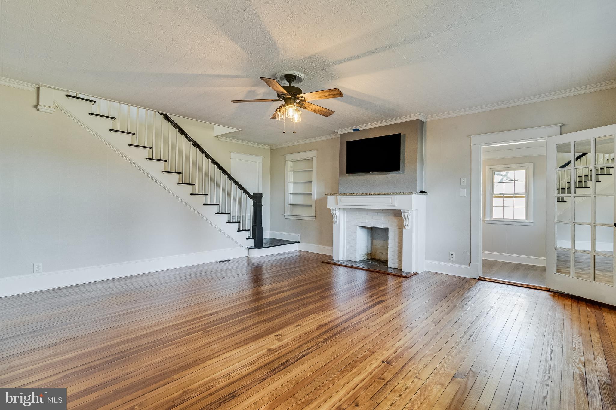 28055 Old Village Road Mechanicsville, MD 20659 - Photo 16 of 56 a view of an empty room with wooden floor fireplace and a window