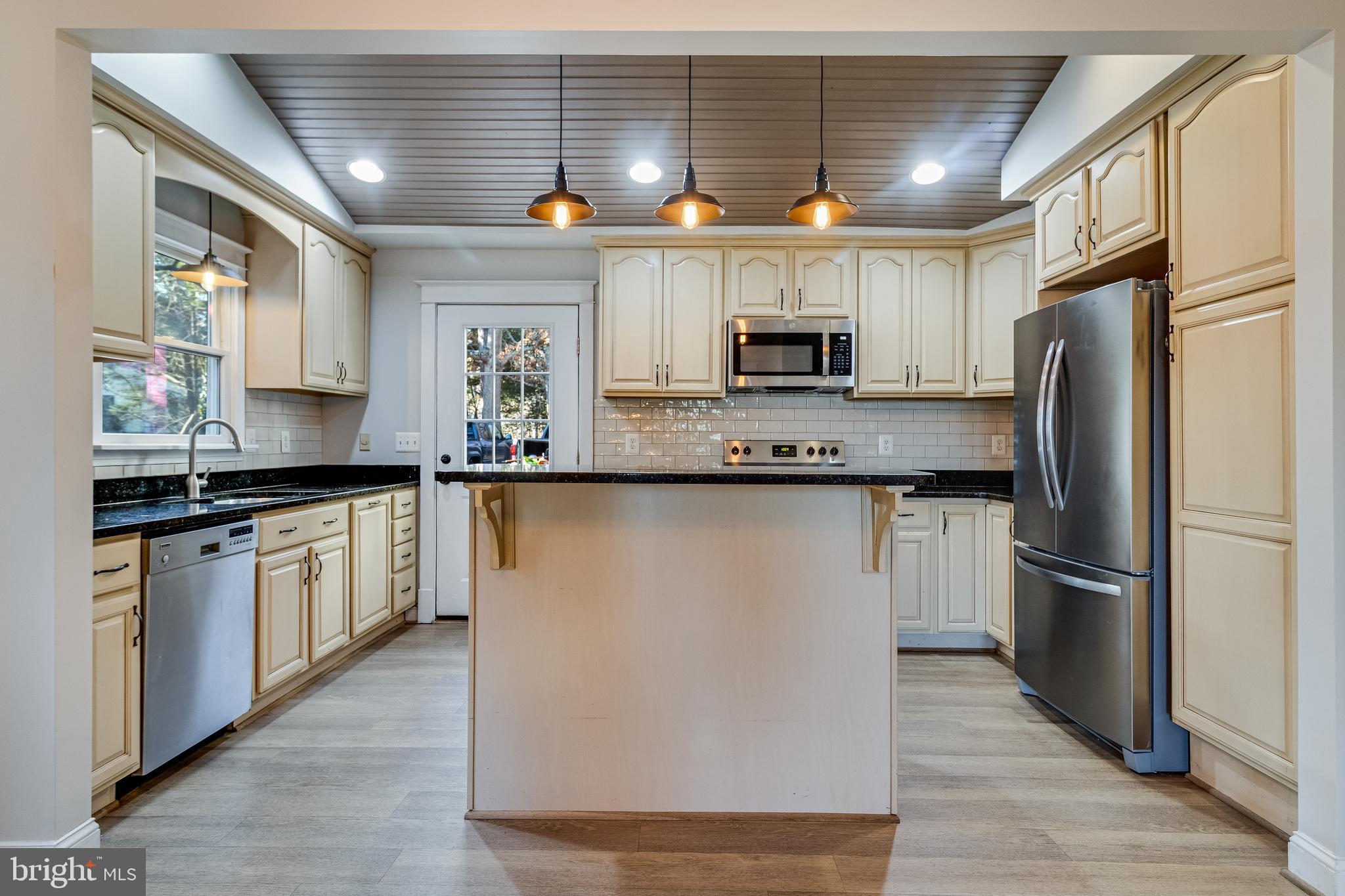 28055 Old Village Road Mechanicsville, MD 20659 - Photo 10 of 56 a kitchen with kitchen island granite countertop a sink stainless steel appliances and counter space