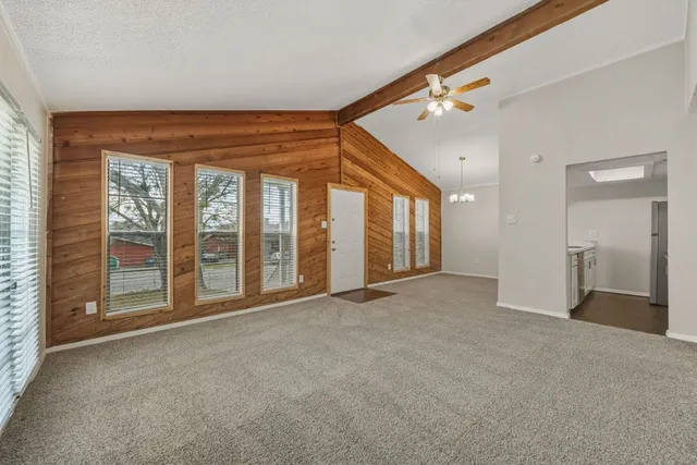 a view of an empty room with a fireplace and a window