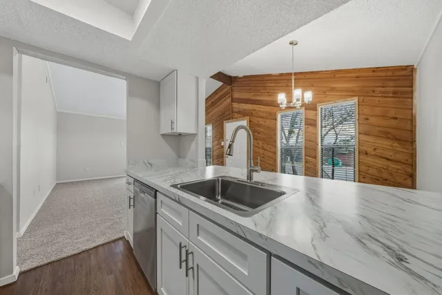 a view of a kitchen with a sink and chandelier