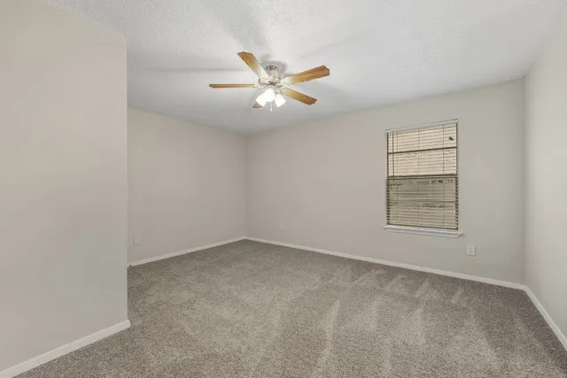 an empty room with closet and ceiling fan