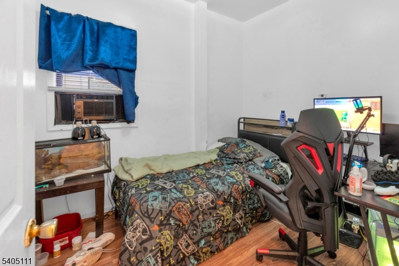 25 Oak Street, Unit 25 Paterson, NJ 07501 - Photo 11 of 25 a bedroom with a bed closet and flat tv screen