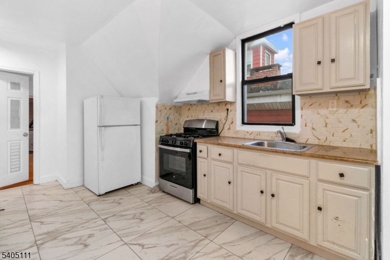 25 Oak Street, Unit 25 Paterson, NJ 07501 - Photo 16 of 25 a kitchen with granite countertop white cabinets stainless steel appliances and sink