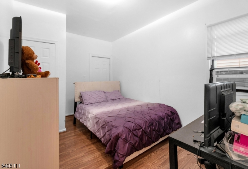 25 Oak Street, Unit 25 Paterson, NJ 07501 - Photo 8 of 25 a bedroom with a bed and a flat screen tv