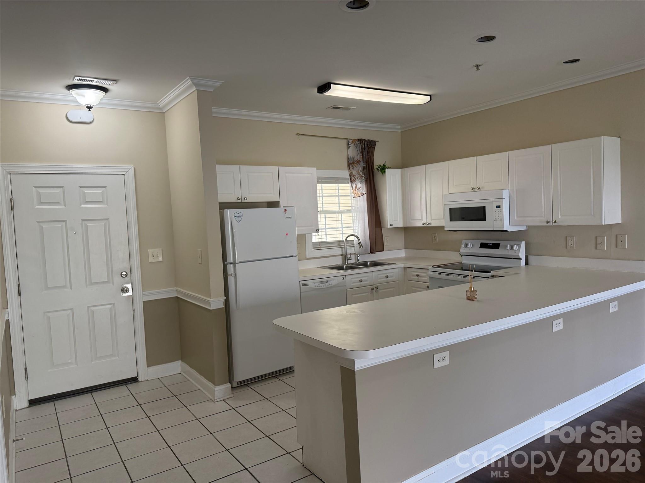 8913 Meadow Vista Road Charlotte, NC 28213 - Photo 4 of 30 a view of a kitchen with a sink and dishwasher a refrigerator with white cabinets