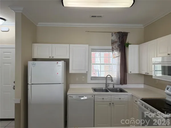 a kitchen with a sink a refrigerator and window