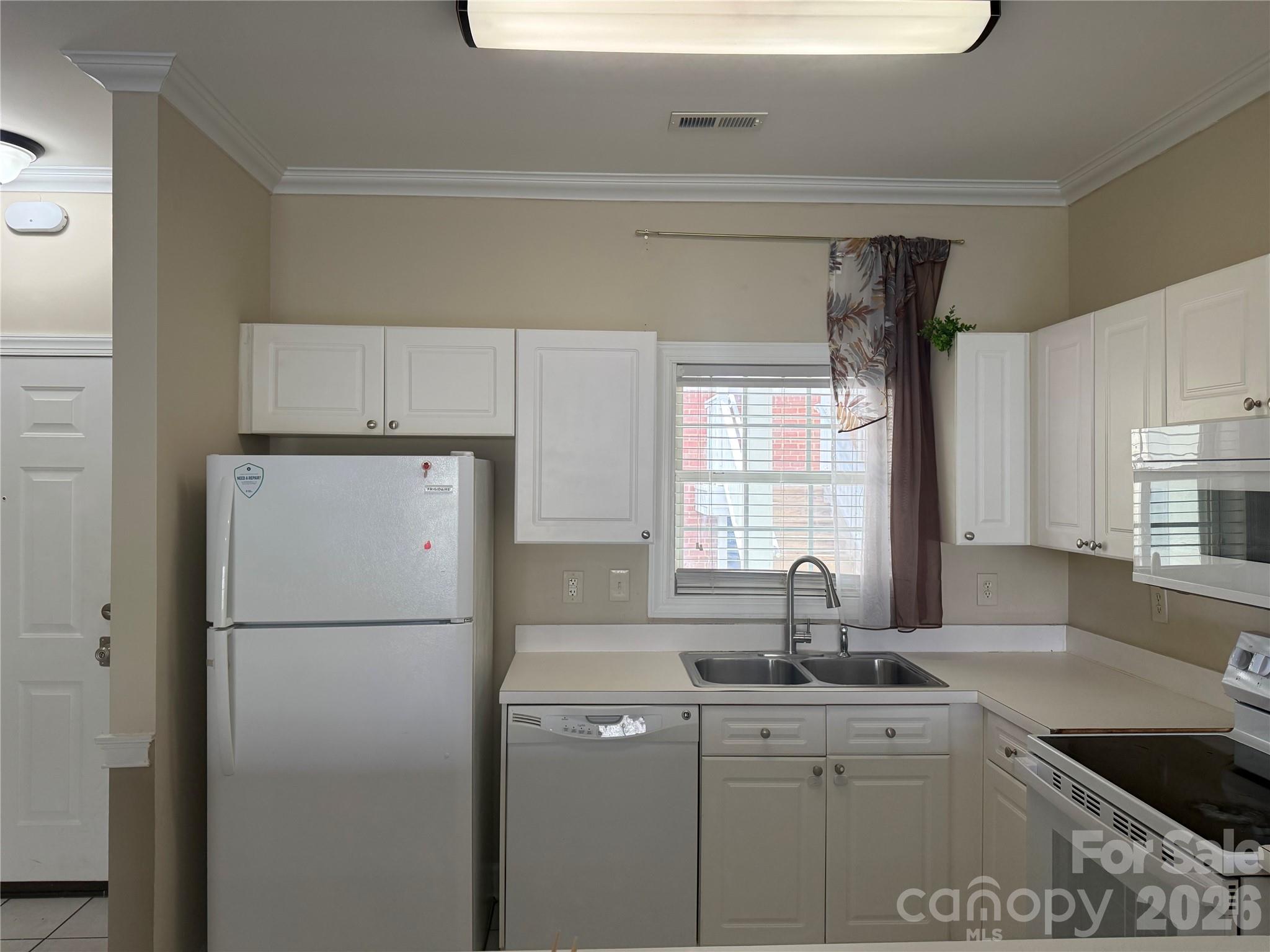 8913 Meadow Vista Road Charlotte, NC 28213 - Photo 8 of 30 a kitchen with a sink a refrigerator and window