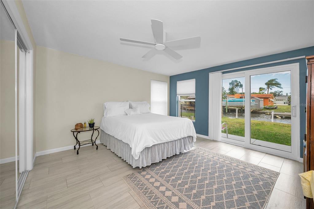 5433 Bluepoint Drive Port Richey, FL 34668 - Photo 11 of 50 a spacious bedroom with a bed and glass door