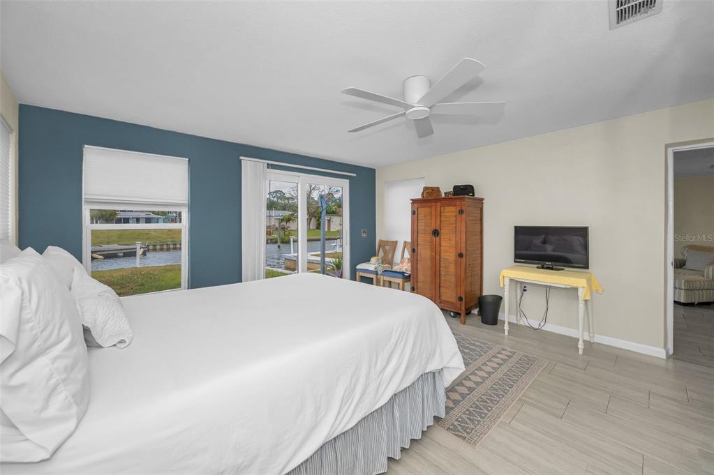 5433 Bluepoint Drive Port Richey, FL 34668 - Photo 13 of 50 a bedroom with a bed a flat screen tv and a window