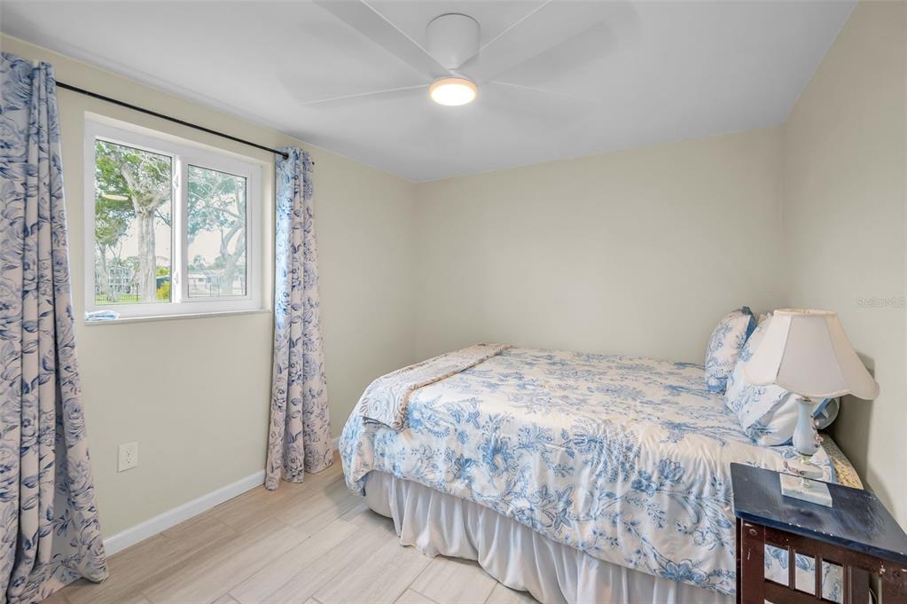 5433 Bluepoint Drive Port Richey, FL 34668 - Photo 17 of 50 a bedroom with a bed and wooden floor