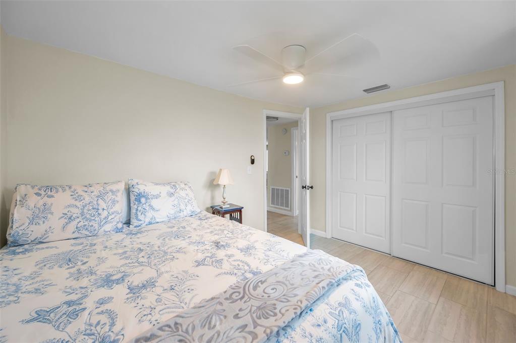 5433 Bluepoint Drive Port Richey, FL 34668 - Photo 18 of 50 a bedroom with a large bed and a chandelier