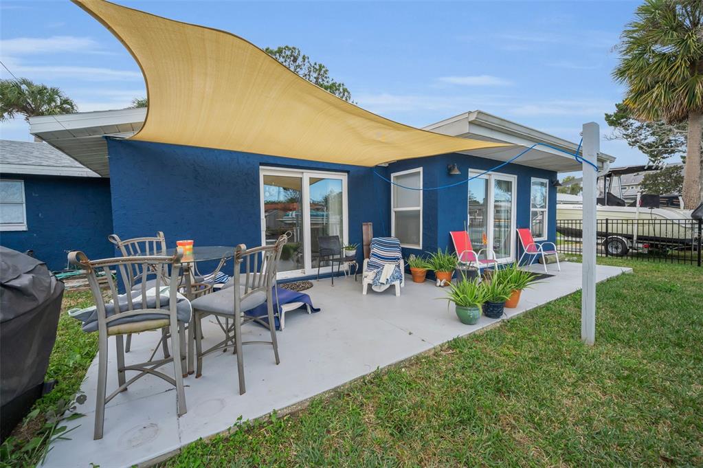 5433 Bluepoint Drive Port Richey, FL 34668 - Photo 27 of 50 a view of a patio with table and chairs under an umbrella