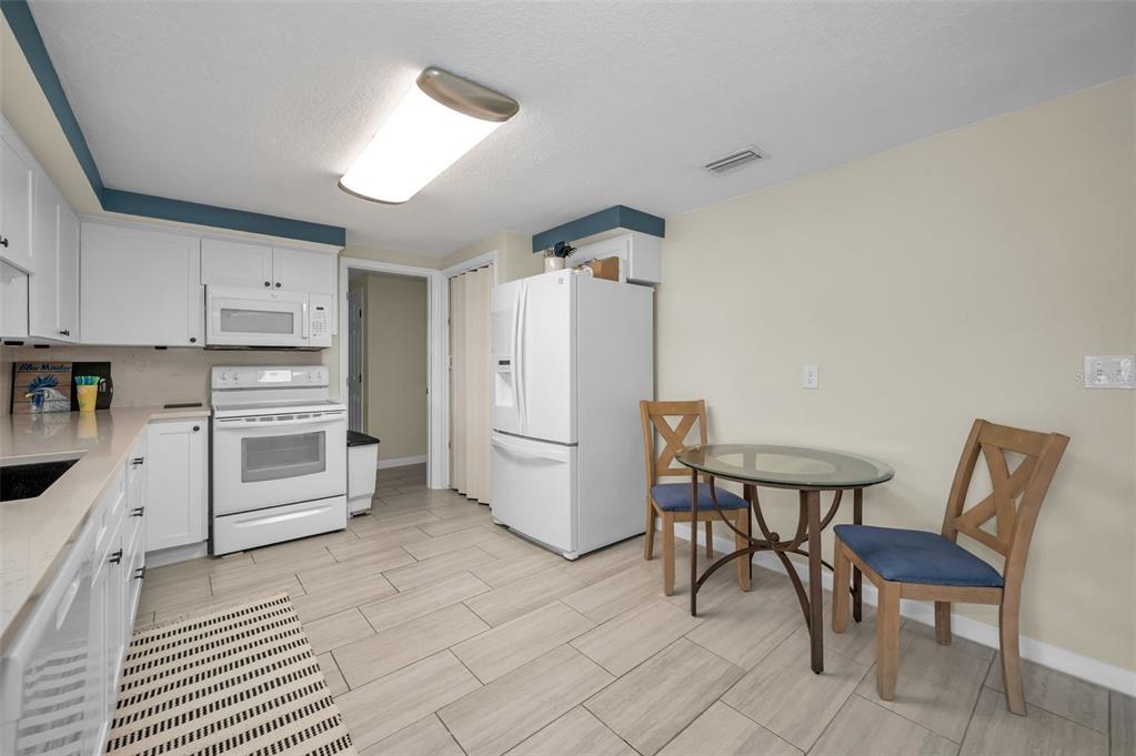 5433 Bluepoint Drive Port Richey, FL 34668 - Photo 7 of 50 a kitchen with a table chairs and a refrigerator