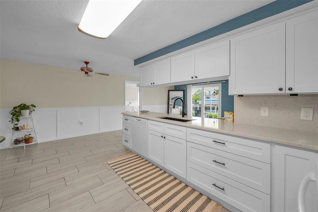 5433 Bluepoint Drive Port Richey, FL 34668 - Photo 9 of 50 a kitchen with granite countertop white cabinets and white appliances