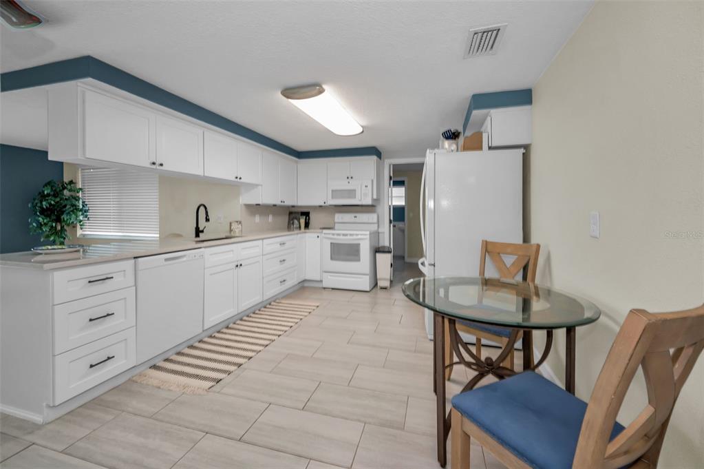 5433 Bluepoint Drive Port Richey, FL 34668 - Photo 10 of 50 a kitchen with white cabinets and appliances