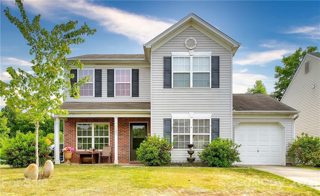 7103 Indian Ridge Lane Charlotte, NC 28214 - Photo 1 of 24 a front view of a house with a yard and garage