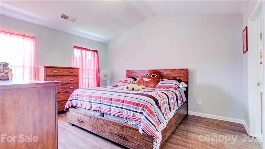 7103 Indian Ridge Lane Charlotte, NC 28214 - Photo 17 of 24 a bedroom with a bed and wooden floor