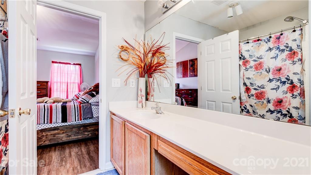 7103 Indian Ridge Lane Charlotte, NC 28214 - Photo 19 of 24 a en suite bathroom with a sink a vanity and a mirror