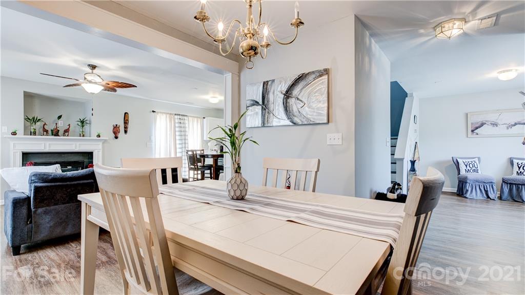 7103 Indian Ridge Lane Charlotte, NC 28214 - Photo 4 of 24 a dining room with wooden floor a chandelier a wooden table and chairs